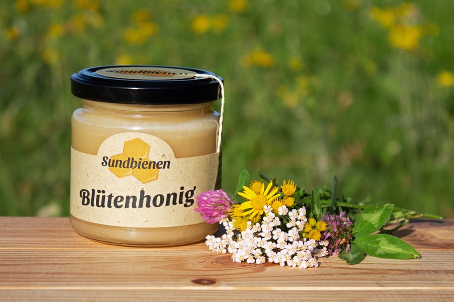 Cremiger regionaler Honig aus Mecklenburg-Vorpommern auf Holzbrett