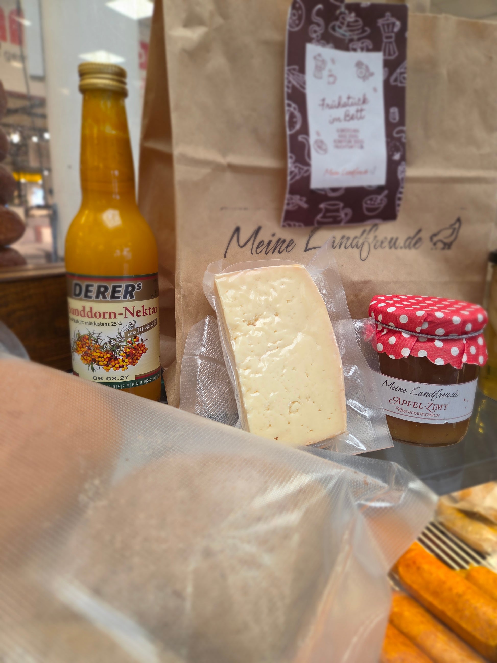 Nahaufnahme von 6 knusprigen Brötchen, Käseplatte und Saft aus dem Valentinstags-Set für ein regionales Frühstück.